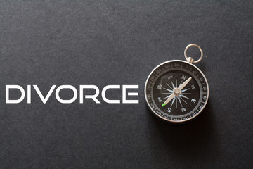 Divorce word written on black background with compass