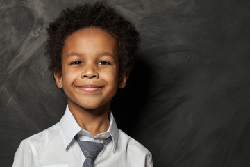 Happy kid boy on blackboard background. Smiling child face close up portrait - Powered by Adobe