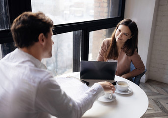 Colleagues discussing work over a cup of coffee. Young businesswoman performs a job interview....
