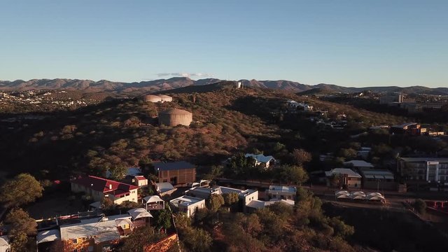 4K aerial Windhoek capital residential central hilly district bright sunset drone video with upmarket houses and old white walls German mansion on top of hill in Khomas Region, central Namibia