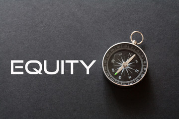 Equity word written on black background with compass