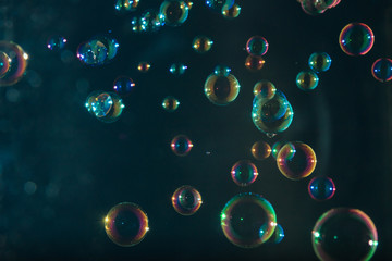 Soap bubbles colorful float on dark background