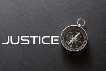 Justice word written on black background with compass