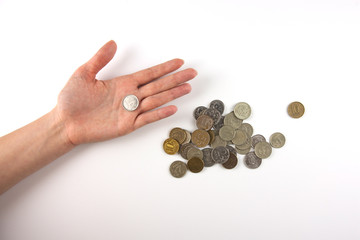 Coin in the hand with other coins.