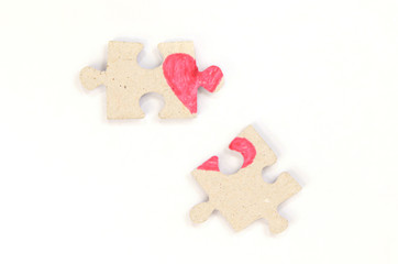 Puzzle with a red heart on the white isolation background. Two disconnected halves Valentine's day stock photo with empty space for your text. For web, print, postcard, background and wallpaper 