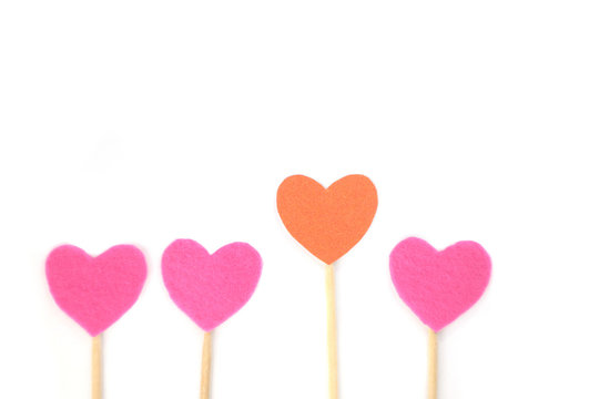 Felt orange and pink hearts on a stick on a white isolated background. Stock photo for the day of St. Valentine with empty space for your text. For web, print, postcards and wallpaper.