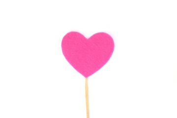 Оne pink felt heart on a stick on a white isolated background. Stock photo for the day of St. Valentine with empty space for your text. For web, print, postcards and wallpaper.