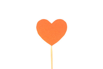 Оne felt orange heart on a stick on a white isolated background. Stock photo for the day of St. Valentine with empty space for your text. For web, print, postcards and wallpaper.