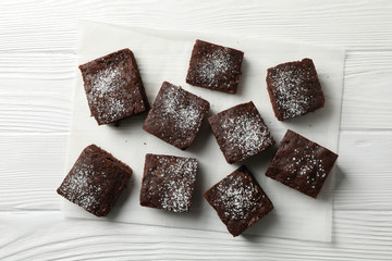 Chocolate cake slices on white wooden background, top view