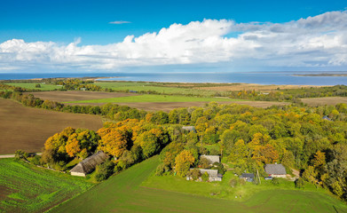 Aerial scenery of the autumn colored traditional rural landscape and the water of the seabay in...