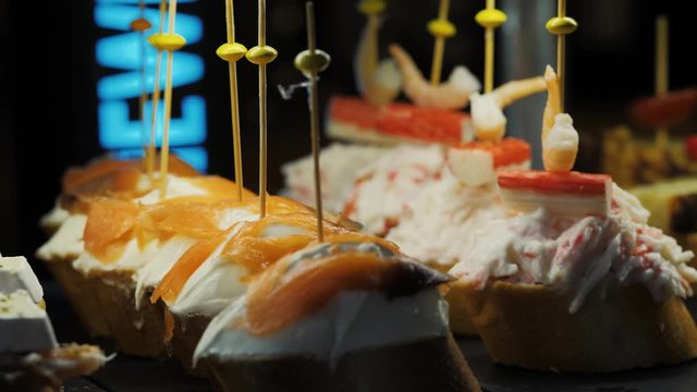 Showcase window display assortiment with tapas – traditional Spanish sandwiches starters in a cafe in Barcelona, Spain close up macro