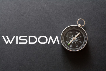 Wisdom word written on black background with compass