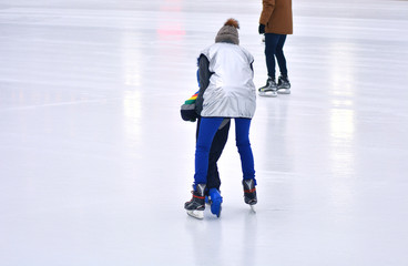 A coach teaches a child to skate