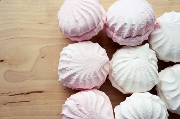 White and pink marshmallows on a wooden table