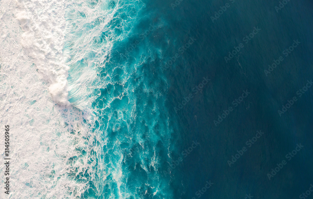 Wall mural aerial view to waves in ocean splashing waves.