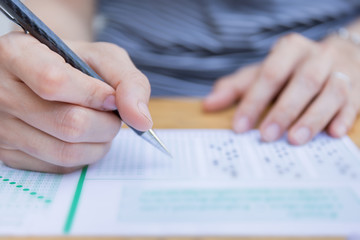 high school,university student study.hands holding pencil writing paper answer sheet.sitting lecture chair taking final exam attending in examination classroom.concept scholarship for education abroad