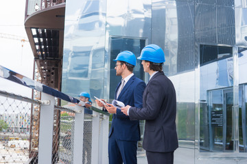 Real estate developers in helmets. New office construction. Confident business men and architect...