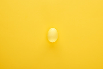 Top view of painted Easter egg on colorful yellow background
