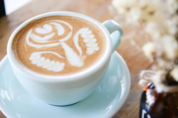 Coffee cup with Latte art on wooden table menu in coffee break time.Latte art froth design pattern is a method of preparing coffee.