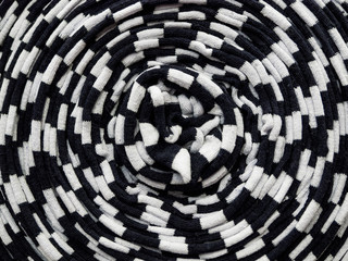 A roll of knitted fabric in black and white. Texture, background