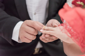 Obraz premium Wedding ring.Groom put the wedding ring on bride.Thai traditional wedding ceramony decoration