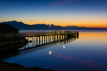Fototapeta premium Steg am See und Berge - Chiemsee am Abend