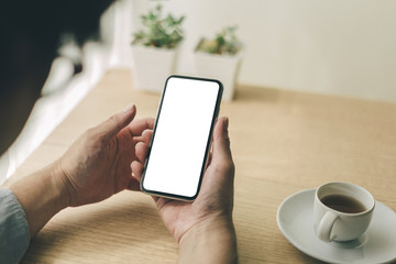 Mockup image blank white screen cell phone.man hand holding texting using mobile on desk at office.background empty space for advertise text.people contact marketing business,technology 