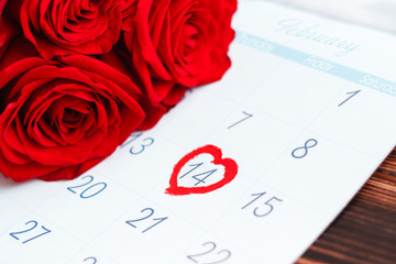 Open calendar February 2020 with the marked date with a heart on 14 Valentines day. Red roses on...