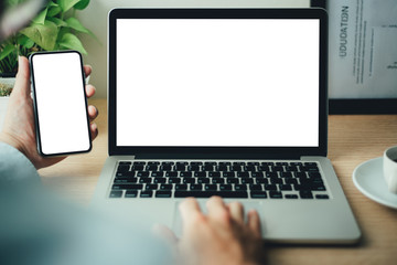mockup image blank screen computer,cell phone with white background for advertising text,hand man using laptop texting mobile contact business search information on desk in office.marketing,design