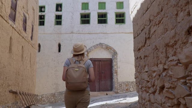 Young Woman Visiting Abandoned Old Ruined Village of Al Hamra near Nizwa, Oman