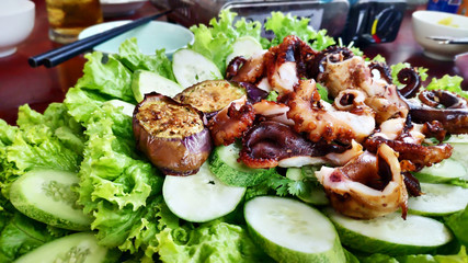Delicious grilled octopus on metal grill seafood bbq with chili sauce spring onion tentacles calamari tasty marinated Vietnamese street food Asian cuisine