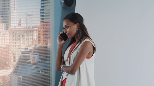 Close-up of attractive african model has stopped talking on smartphone and begins working. The photographer asked her to leave talking because of lack of time.