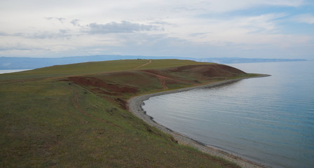Fototapeta na wymiar beatifull landscape with green lake shore and cloudy sky