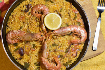 seafood paella on the table with lemon and next to fork