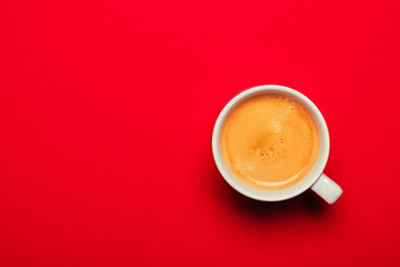 Black coffee in a cup on a red background