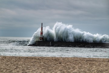 Giant waves breaking on the breakwater and the lighthouse