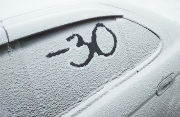 The inscription on a snowy car minus 30 degrees, the concept of harsh winter and frost, weather forecast.