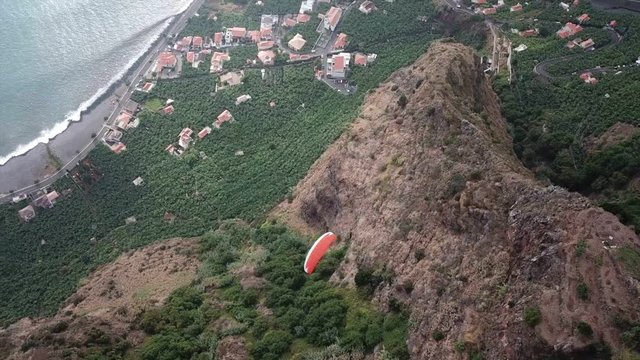 Drone aerial view of paraglider man flying over clouds and in Madeira island, Portugal