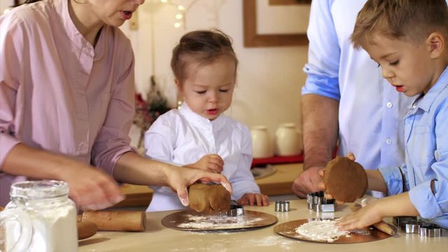 Whole family is making cookies together for Christmas at xmas eve. Family of five people is preparing a dough for cookie 