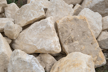 Big pile of large sand stones laying on the ground of construction site.