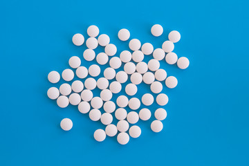 Pile of the white tablets on blue background
