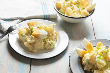 Potato salad with egg and mayonnaise on wooden background