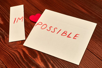 The inscription is impossible cut off so it is written possible on white paper on a dark wooden...