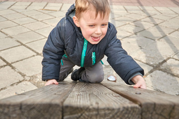 Fototapeta premium little boy is climbing on a wooden board.