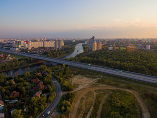 Obraz premium Summer landscape with a bird's-eye view of the city and the motorway.