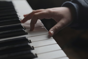 Naklejka na ściany i meble children's hand on the piano