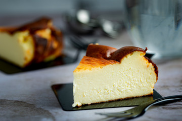 Close up of Basque Burnt Cheesecake on black dessert plate