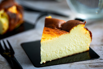 Close up of Basque Burnt Cheesecake on black dessert plate