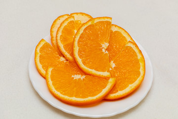 Slices of orange on a plate on a light background. Tangerines, Citrus, Fruits, Food, Vitamin C, Detox. Minimalism style.