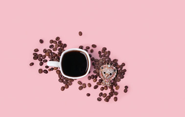 cup of black coffee, coffee beans and cute jewelry lion brooch on pink background. Luxurious jewelry in form of a lion. minimal composition, copy space. flat lay, template for design